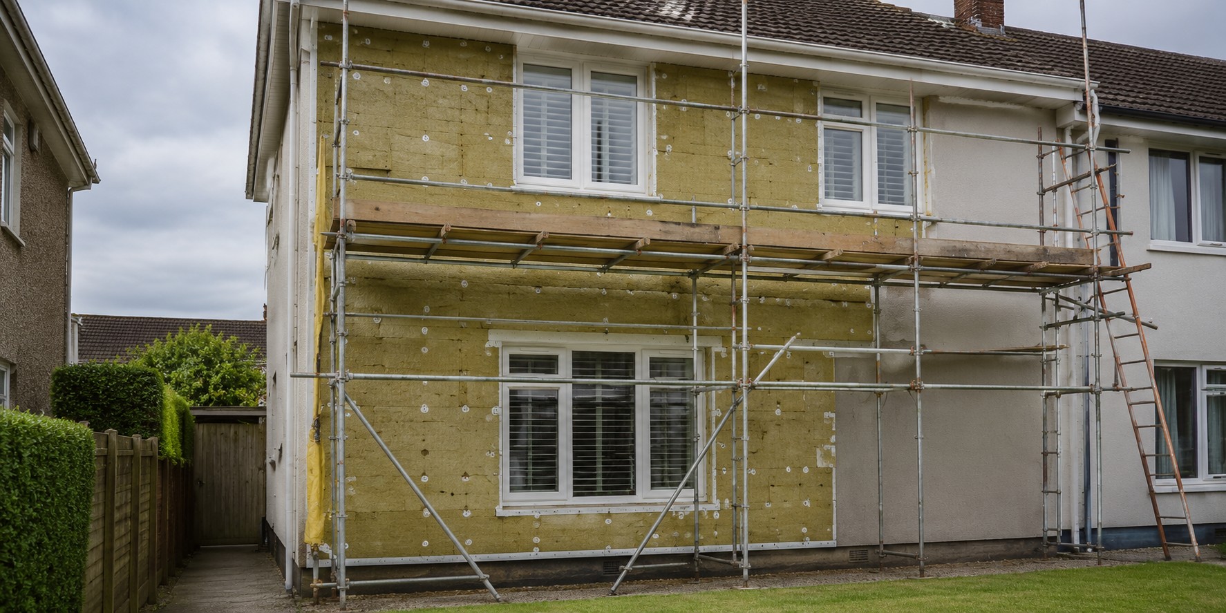 A house part-clad in insulation board with scaffolding in place
