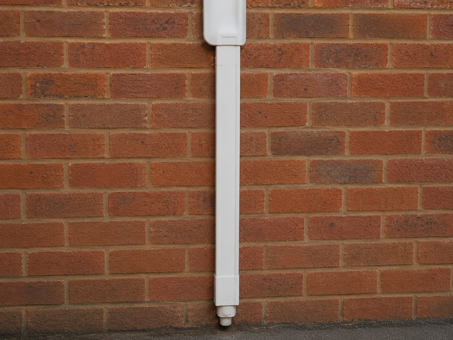 Pipework and condensate run clipped to an outside wall