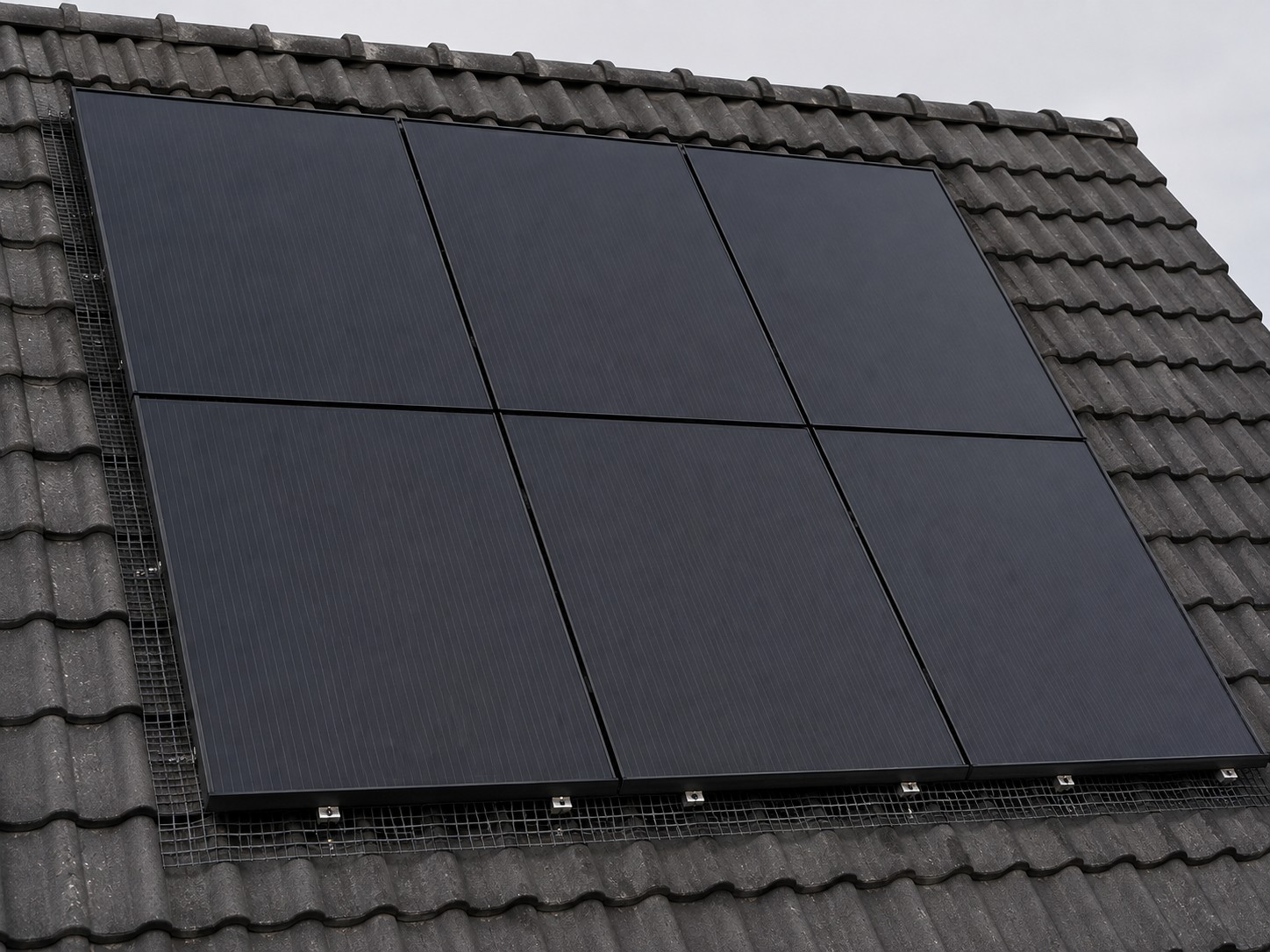 Black solar panels fitted flush to a tiled roof