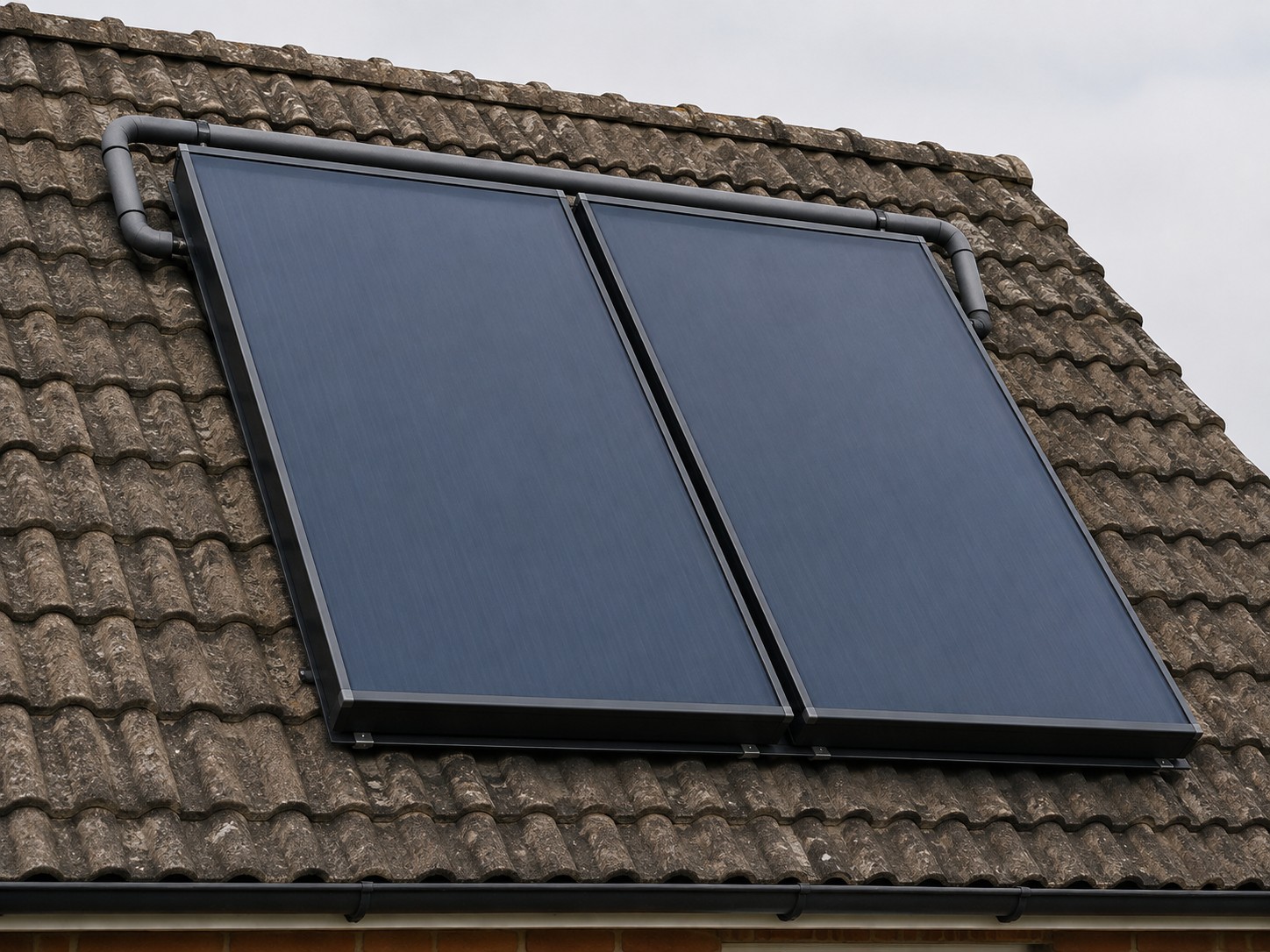 Two solar thermal collectors set into a tiled roof