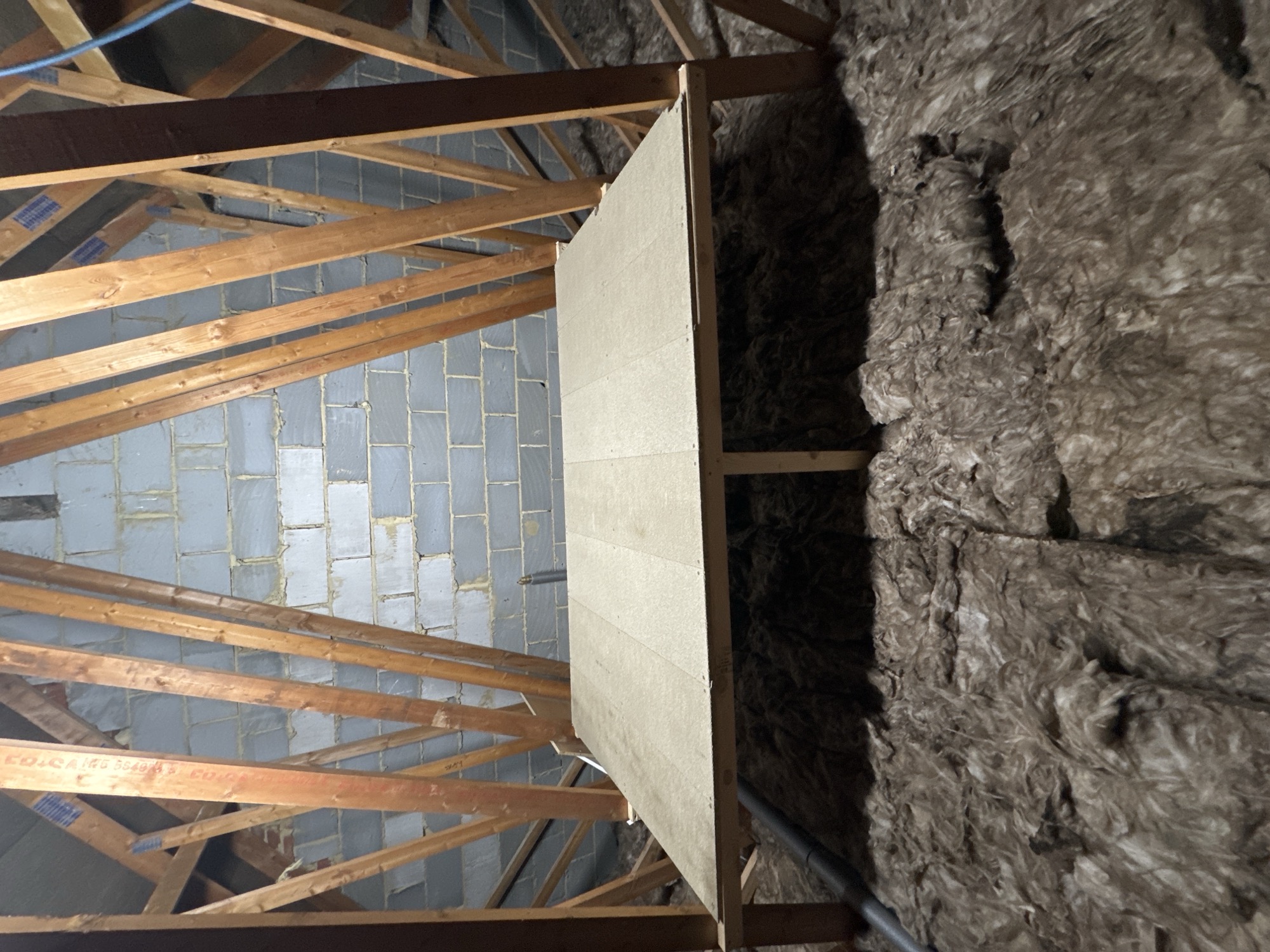 Loft insulation laid between and over the joists