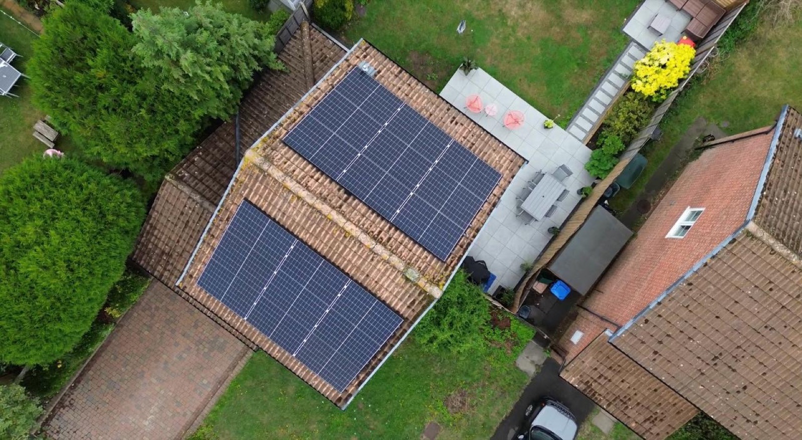 Aerial view of two solar arrays on a house roof